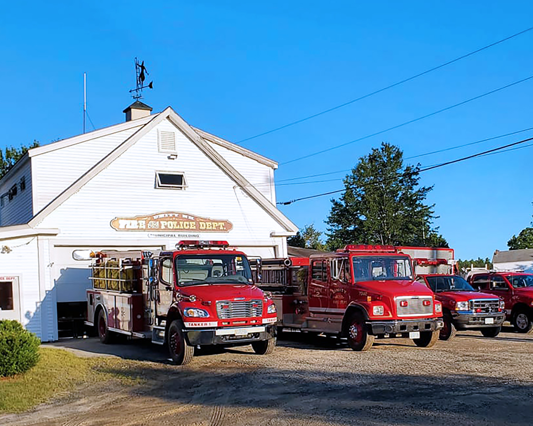 Several red and white Town of Unity NH Fire Department firetrucks and rescue vehicles.