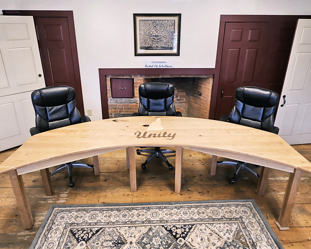 Town of Unity, NH Selectmen Meeting Room showing a semi-round wooden table and black leather chairs